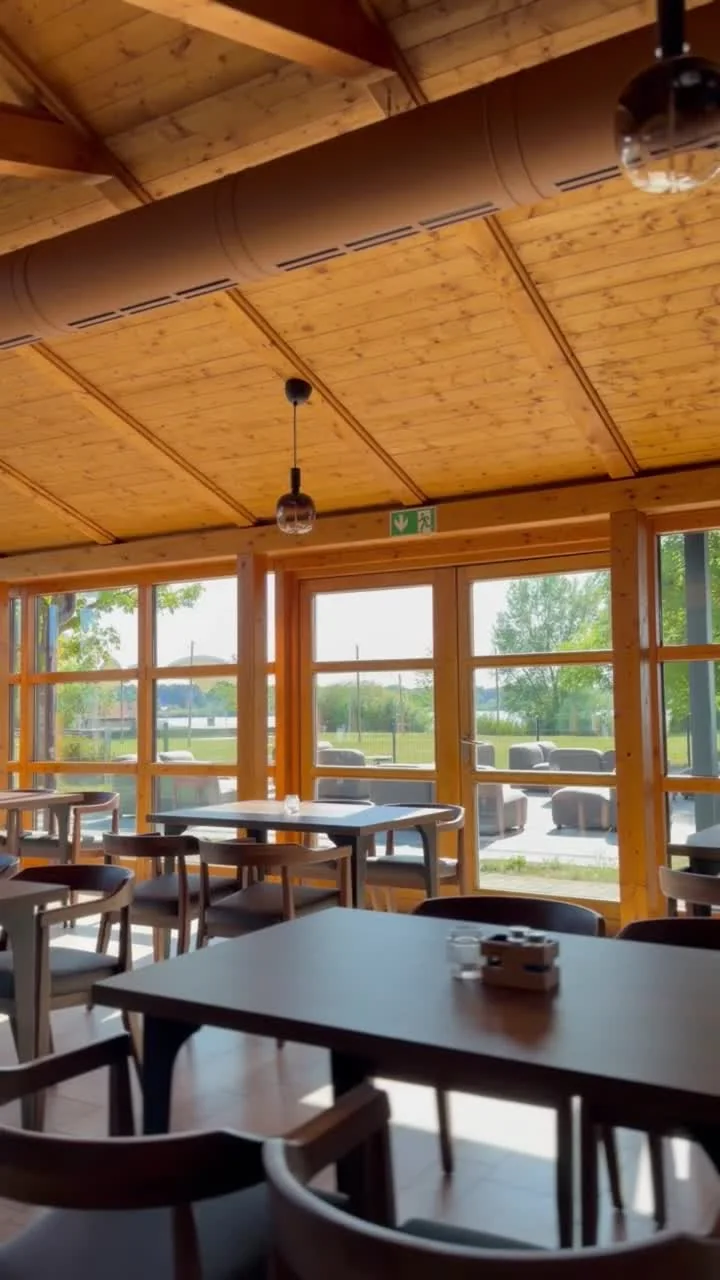 Heller Gastraum mit Holzdach und Blick zur Seeterrasse